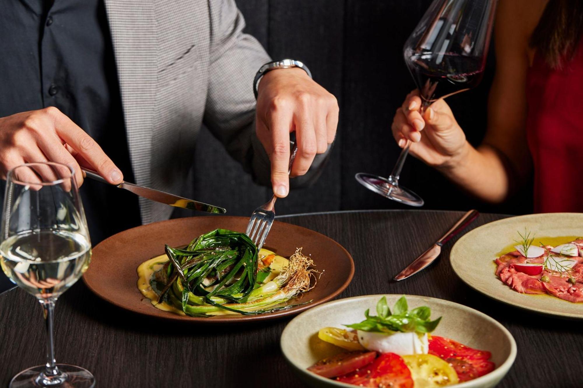 Melbourne Marriott Hotel Docklands מראה חיצוני תמונה A man using a knife and fork to cut into a meal